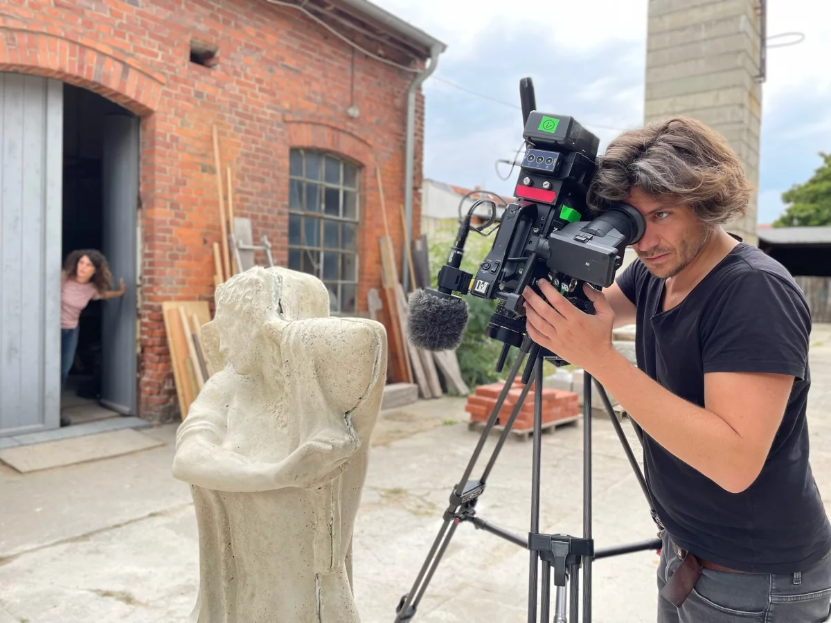 Ein Kameramann filmt eine Skulptur